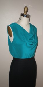 Top turned backwards, worn with cowl drape in front.