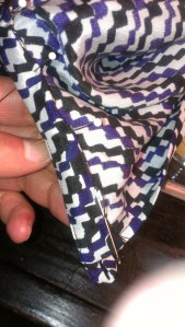 Slip stitching the inside of the neck band by hand